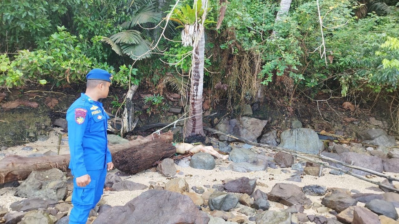 Petugas Ditpolairud Polda Sumbar bersama tim SAR mengevakuasi mayat pria tak dikenal yang ditemukan nelayan di Pantai Bukit Lampu Padang