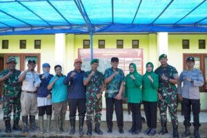 Foto bersama sekelompok orang yang terdiri dari personel TNI (Yonif 509), anggota Polri, dan warga sipil di depan sebuah bangunan dengan spanduk bertuliskan "Kegiatan Ketahanan Pangan". Sebagian besar berpose mengepalkan tangan ke depan sebagai simbol semangat.