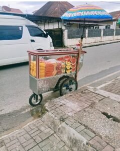 Bantuan Gerobak DPRD Sumbar baru untuk UMKM Bukittinggi, diisi aneka buah segar seperti semangka dan nanas, diberikan oleh Hj. Yesi Endriani
