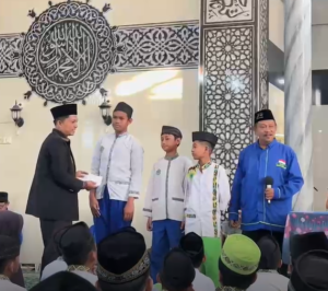 Kepala KUA Kecamatan Lubuk Begalung, Jasrizal, bersama Ketua LDS Kota Padang, Herman Dodoi, menyerahkan penghargaan (reward) kepada santri terbaik sebagai bentuk apresiasi atas prestasi dan penampilan terbaik dalam kegiatan Didikan Shubuh Gabungan TPQ-TQA dan MDTA se-Kelurahan Banuaran Nan XX di Masjid Muta'alimin, Ahad (14/6/2026).