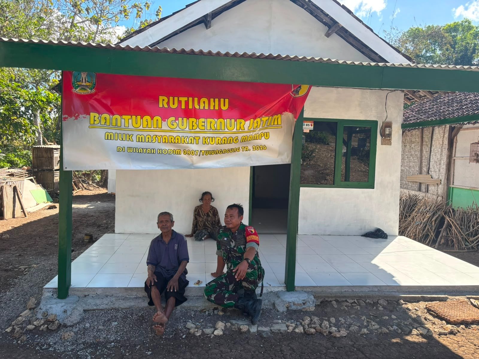 Babinsa Desa Ngepoh Serka Miswan bersama Mbah Bejo di depan rumah baru hasil Program Rutilahu Bantuan Gubernur Jawa Timur di Tulungagung.